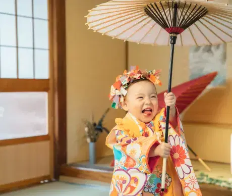 小さい子供が和傘を持って楽しそうにしている